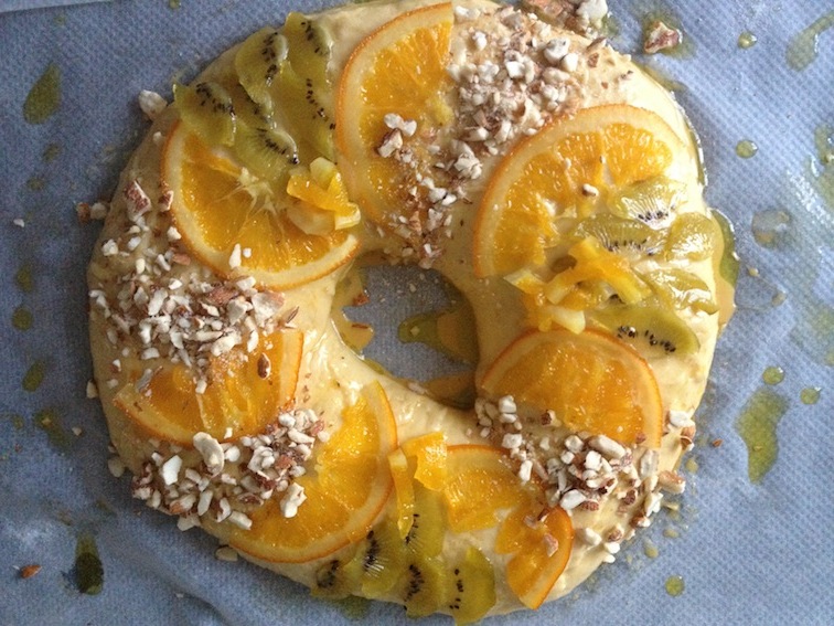 Roscon recien terminado con la fruta confitada (naranja y kiwi) y amendra picada